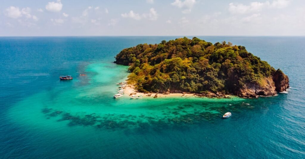 Discover the untouched beauty of a tropical island surrounded by crystal-clear waters from an aerial perspective.
