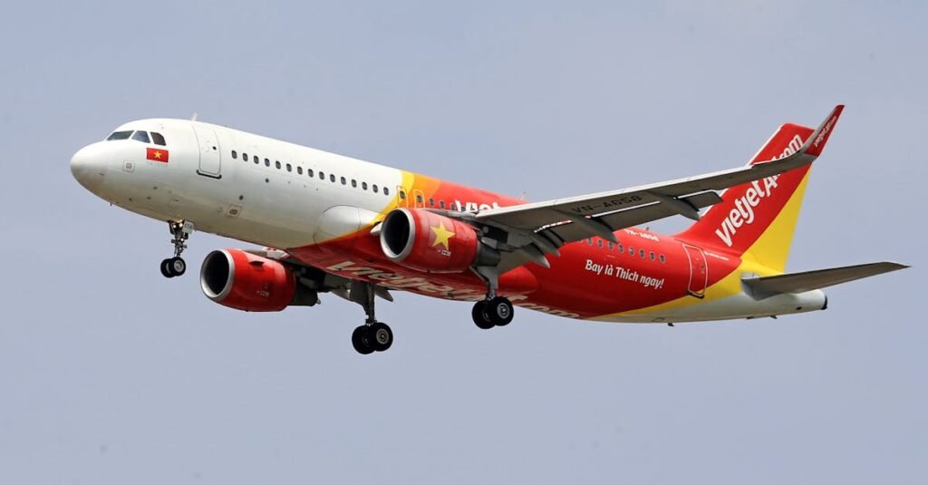 VietJet Air airplane flying with a clear sky background, showcasing vibrant branding.